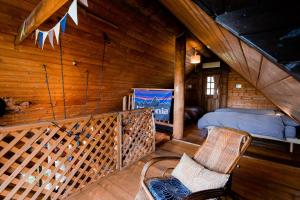 今津Forest Villa Ilio Biwako的小木屋里的阁楼房间里有一张床和几把椅子。