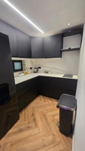 Eine Küche mit schwarzen Schränken und Holzboden in der Unterkunft 658 Suite in Eilat