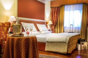 a hotel room with a bed and a table with wine glasses at Hotel La Bussola in Novara