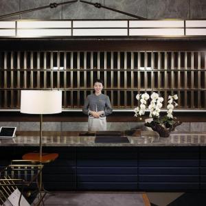 une femme debout derrière un comptoir dans une pièce dans l'établissement Chongqing The Lotus Hotel, à Chongqing 246 autres photos