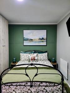 a bedroom with a bed with a green wall at Walnut Studio in Clarens