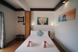 ein Schlafzimmer mit einem weißen Bett und zwei Kissen in der Unterkunft Point 303 Resort in General Luna + 9 Fotos