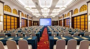 Cette grande chambre dispose de tables et de chaises bleues ainsi que d'un écran. dans l'établissement Jin Jiang Nanjing Hotel, à Nankin