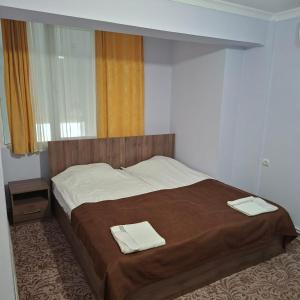 a bedroom with a bed with two towels on it at Hotel International in Yerevan