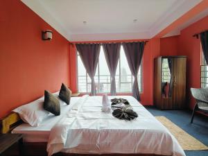a bedroom with a large bed with orange walls at Serenity Nest in Lava