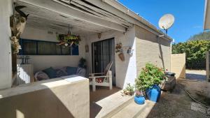 ein kleines weißes Haus mit einer Veranda und einigen Pflanzen in der Unterkunft Bella Casa1 in Velddrif