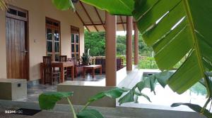 eine Veranda eines Hauses mit einem Tisch und Stühlen in der Unterkunft Shan Mango Homestay in Sigiriya