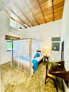 ein Schlafzimmer mit einem Himmelbett in der Unterkunft Coastal Cloud Surf - Walk To Dewata Beach in Unawatuna + 65 Fotos