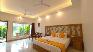 a bedroom with a bed and a large window at Ice Cloud Munnar Pool Resort in Munnar