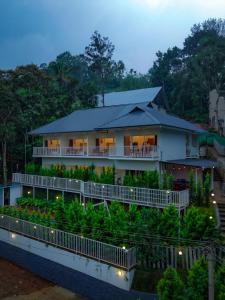 a house on a hill with its lights on at Ice Cloud Munnar Pool Resort in Munnar