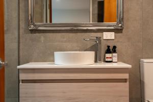 une salle de bain avec un lavabo et un miroir dans l'établissement Stunning Lake Views, à Queenstown