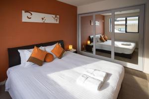 1 dormitorio con 1 cama blanca grande y paredes de color naranja en Powder Haven, en Kutchan