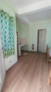 une pièce vide avec un parquet et un bureau dans l'établissement Suki Beach Resort Standard Aircon Room D, à Santa Magdalena