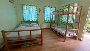 Cette chambre comprend 2 lits superposés et 2 fenêtres. dans l'établissement Suki Beach Resort Standard Aircon Room D, à Santa Magdalena