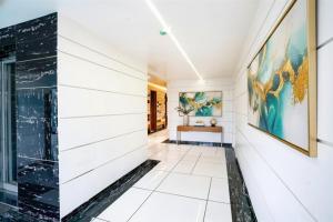 a hallway with white walls and a large painting on the wall at FabHotel The Nashik Inn - Nr Vijay Mamta Theatre, Nashik Road in Nashik