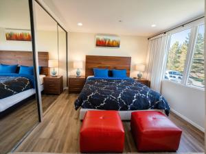 a bedroom with a bed and two red ottomans at Santa Monica Executive Suites in Los Angeles