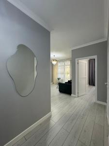 ein leeres Wohnzimmer mit einem Spiegel an der Wand in der Unterkunft ЖК Only sun в 10 минутах от Аэропорта in Prigorodnyy