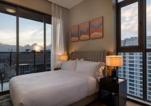 une chambre avec un grand lit blanc et un balcon dans l'établissement Pan Pacific Serviced Suites Nairobi, à Nairobi 95 autres photos