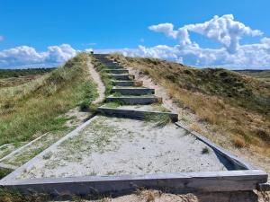 un chemin de terre sur une colline avec du sable et de l'herbe dans l'établissement 16 person holiday home in Rømø, à Rømø Kirkeby 29 autres photos