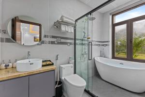 a bathroom with a tub and a toilet and a sink at Ha Giang Hill Hotel in Dồng Văn +65 photos