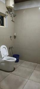 um banheiro com um vaso sanitário branco em um quarto em സ്നേഹ തീരം em Vagamon