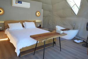 1 dormitorio con cama y bañera en una tienda en Rabwa Geodesic Dome, en Misfāh
