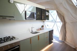 una cocina con fregadero y estufa en Rabwa Geodesic Dome, en Misfāh