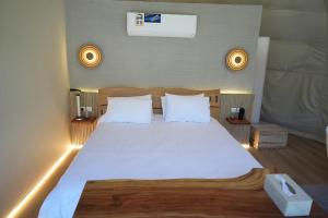a bedroom with a large bed with white sheets and pillows at Rabwa Geodesic Dome in Misfāh
