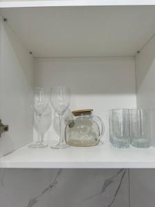ein Regal mit Weingläsern und ein Glas darauf in der Unterkunft ЖК Only sun в 10 минутах от Аэропорта in Prigorodnyy + 8 Fotos