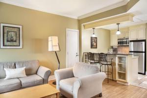 un salon avec un canapé et des chaises et une cuisine dans l'établissement Days Inn by Wyndham Berthierville, à Berthierville