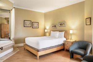 - une chambre avec un lit, une chaise et une baignoire dans l'établissement Days Inn by Wyndham Berthierville, à Berthierville 159 autres photos