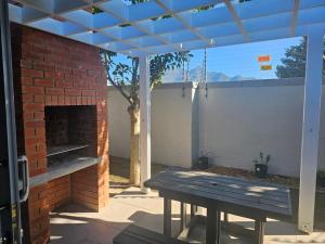 eine Terrasse mit einem Tisch und einem gemauerten Kamin in der Unterkunft 1 on York Townhouse 3 in George