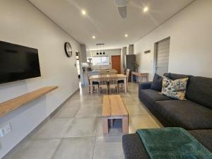 ein Wohnzimmer mit Sofa und Tisch in der Unterkunft 1 on York Townhouse 3 in George