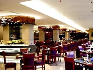 une salle à manger avec des tables et des chaises dans un restaurant dans l'établissement Fangzhong Holiday Hotel, à Chashan