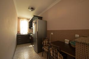 uma cozinha com um frigorífico de aço inoxidável e uma mesa em Angisa Apartment em Batumi