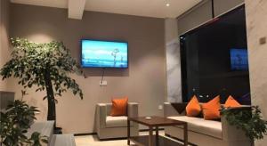 a living room with a couch and a flat screen tv at Jtour Inn Suizhou Yanhe Avenue in Suizhou