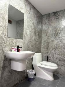 a bathroom with a sink and a toilet and a mirror at Stay at Lanta Bungalow in Ko Lanta