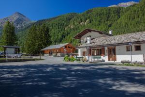 a building in the middle of a road with a mountain at Hotel Camping Grivola in Valsavarenche