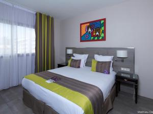 a hotel room with a large bed and a window at Mercure Cayenne Royal Amazonia in Cayenne