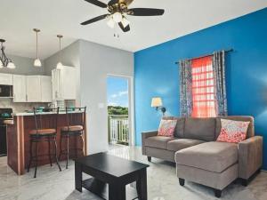 Una sala de estar con un sofá y una cocina. en Tropical paradise, 