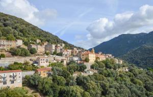 a town on a hill with mountains in the background at 3 Bedroom Awesome Apartment In Olmeto in Olmeto +18 photos