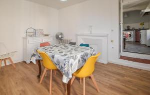a dining room with a table and yellow chairs at 3 Bedroom Awesome Apartment In Olmeto in Olmeto