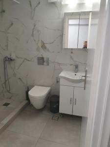 ein weißes Badezimmer mit Toilette und Waschbecken in der Unterkunft Fira Heart Studios in Santorin