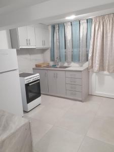 eine Küche mit weißen Schränken und einem Herd mit Backofen in der Unterkunft Fira Heart Studios in Santorin