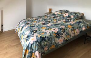 Trézény2 Bedroom Gorgeous Home In Rospez的卧室内的一张带花卉棉被的床