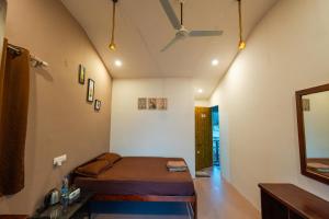 um quarto com uma cama e um ventilador de teto em The Riverside em Mandrem