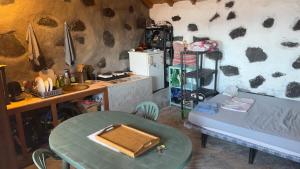 uma sala de estar com uma mesa e uma geladeira em 7 Calcosas em Valverde