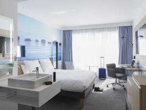 una habitación de hotel con una cama y un lavabo en Novotel Charleroi Centre, en Charleroi 76 fotos más