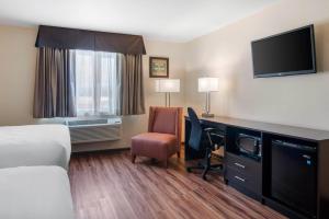 a hotel room with a bed and a desk with a television at Econo Lodge Inn & Suites Springfield Main Street in Springfield +63 photos