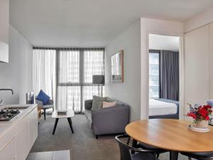 Una cocina y una sala de estar con un sofá y una mesa. en Shadow Play by Peppers, en Melbourne